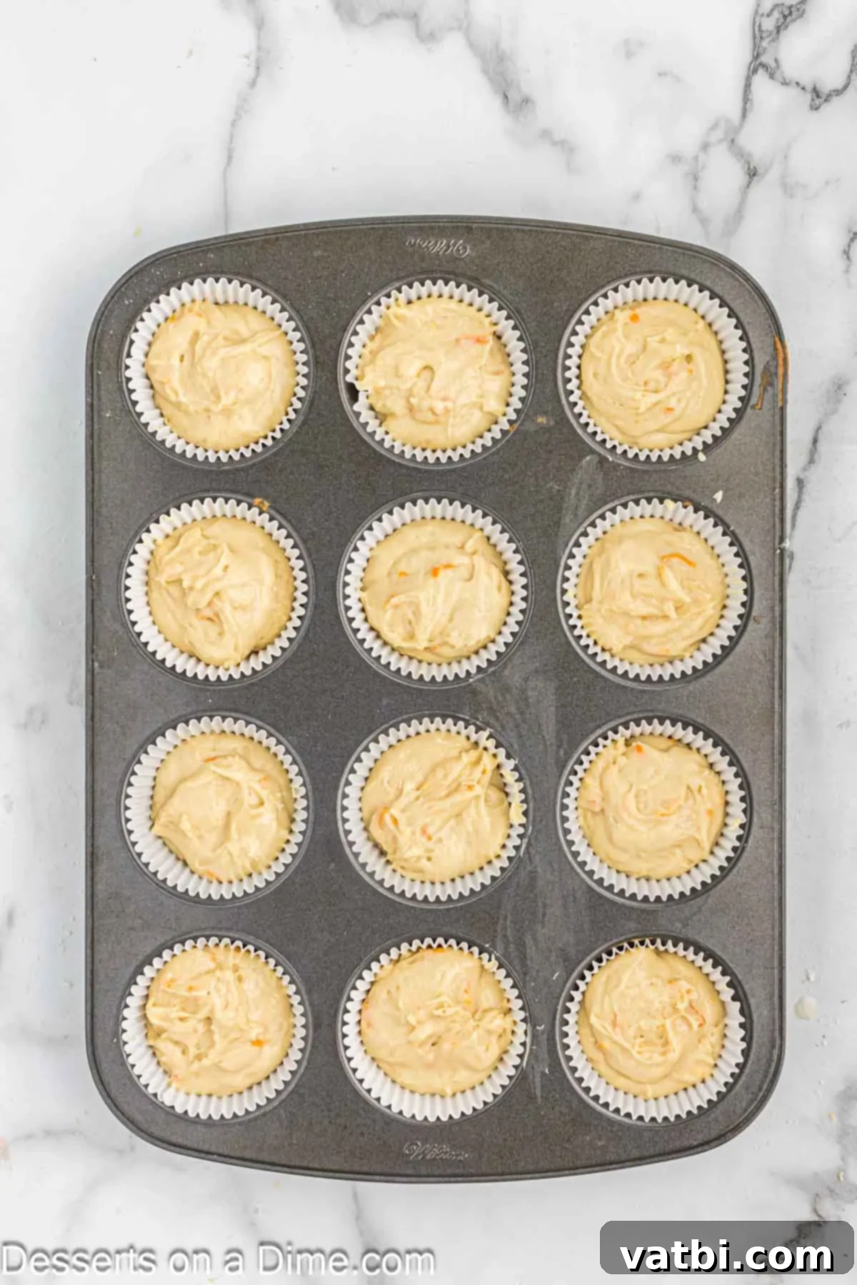 Velvet Orange Dream Cupcakes 7 Cupcake batter poured into cupcake liners in a muffin pan.