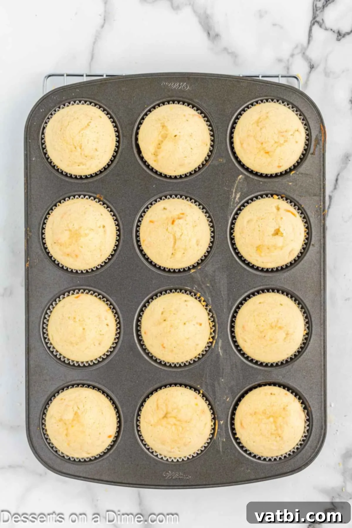 Velvet Orange Dream Cupcakes 8 Baked cupcakes cooling on a wire rack.