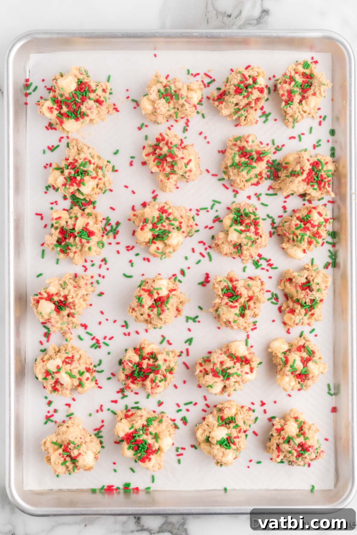Cookies on baking sheet topped with sprinkles.