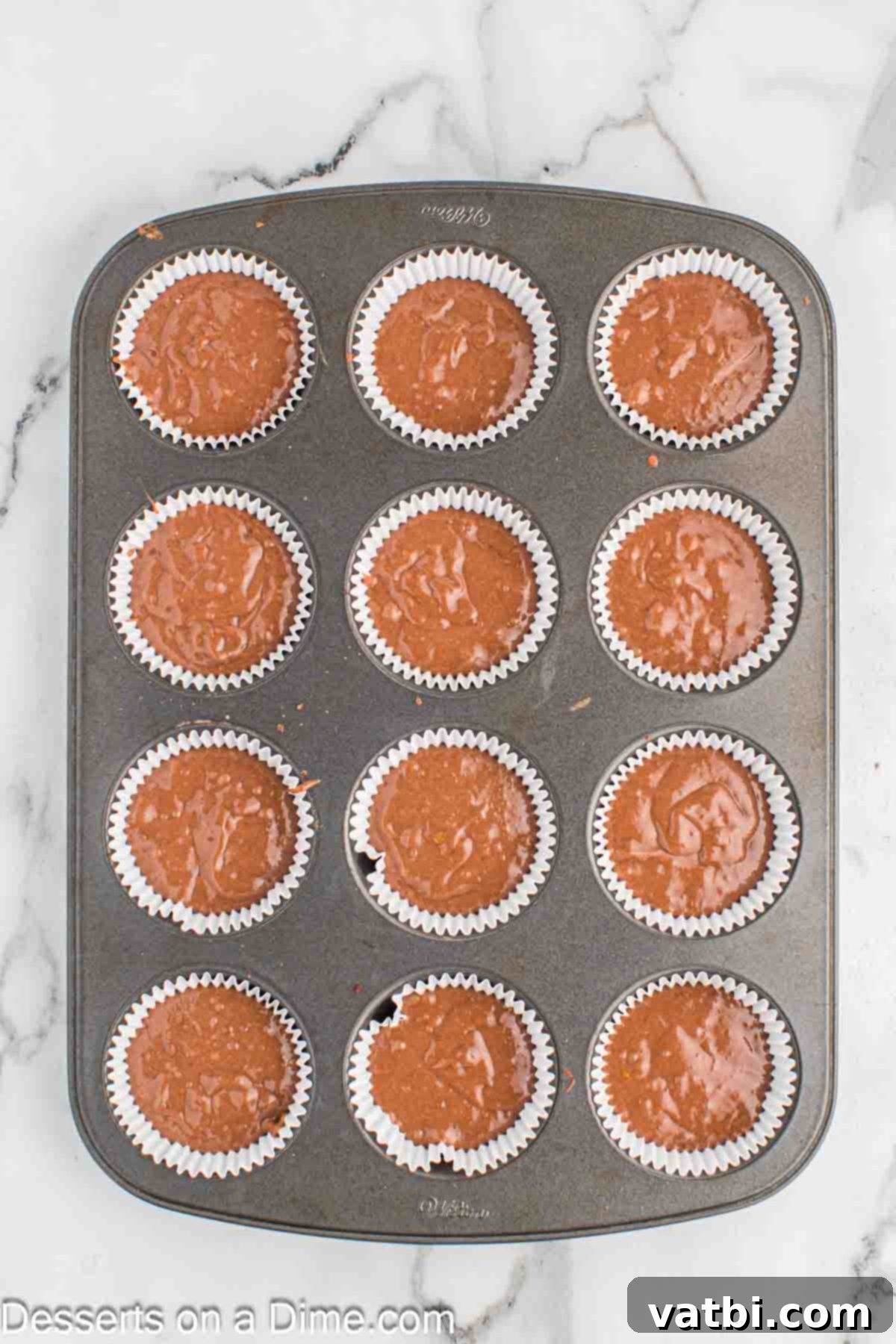 Butterfinger Cupcakes 7 Cupcake batter poured into paper liners within a muffin tin.