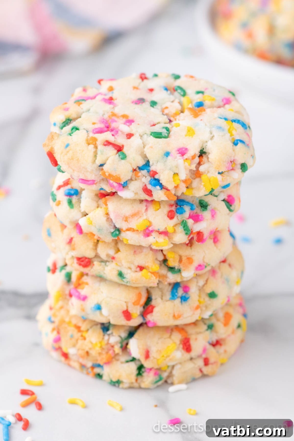 Funfetti Cake Mix Cookies take minutes to make and you only need 3 ingredients. These cookies are fun to make and are perfectly chewy. These easy cookies are one of my favorite recipes. Learn how to make Funfetti cake mix cookies here! #dessertsonadime #cakemixcookies #funfetti Cookies stacked together.