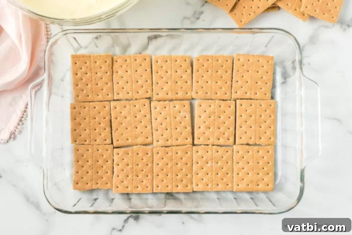 Easy No Bake Eclair Cake 3 Laying the pan with graham crackers