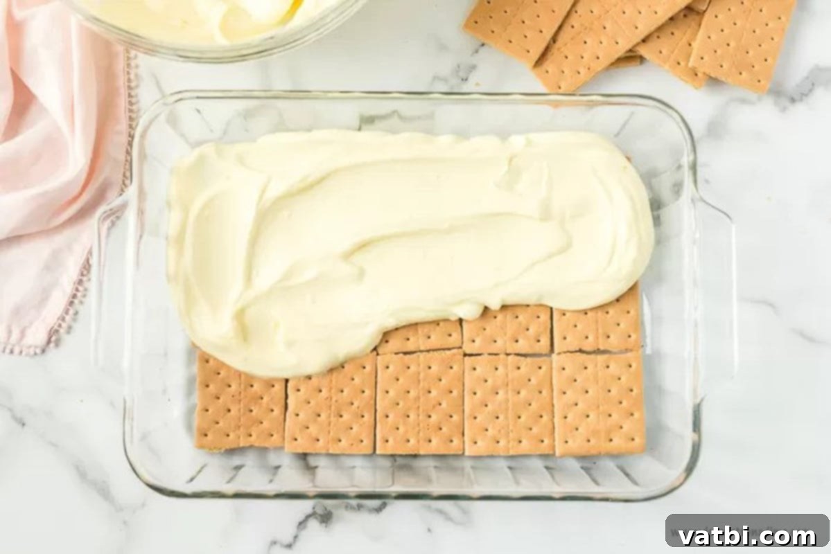 Effortless No-Bake Eclair Cake 4 Layering the graham crackers with vanilla pudding.