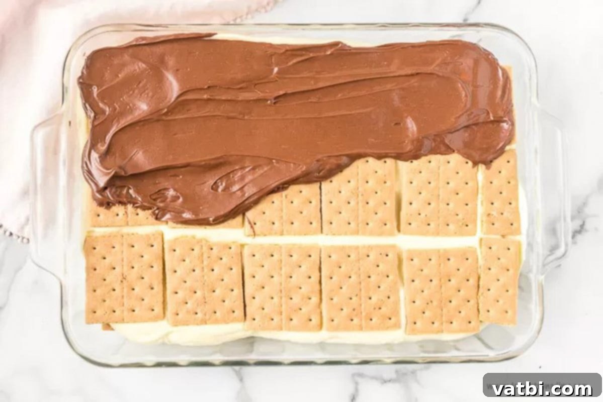 Effortless No-Bake Eclair Cake 6 Layering chocolate on the graham crackers