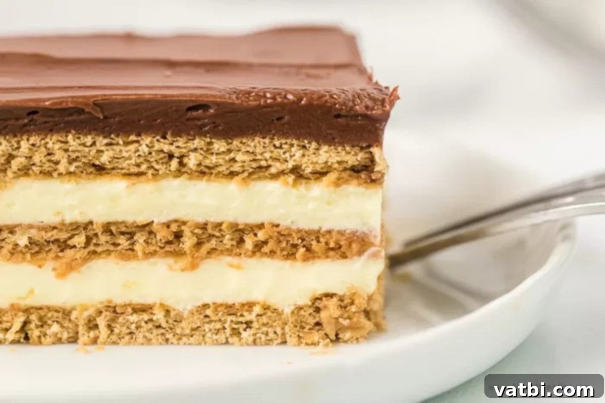 Effortless No-Bake Eclair Cake 7 Close up image of slice of eclair cake on a white plate.