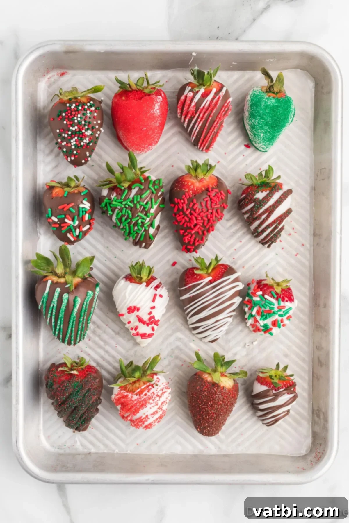 Festive Chocolate Dipped Strawberries 6 A baking sheet lined with parchment paper, holding freshly dipped chocolate covered strawberries topped with festive sprinkles.