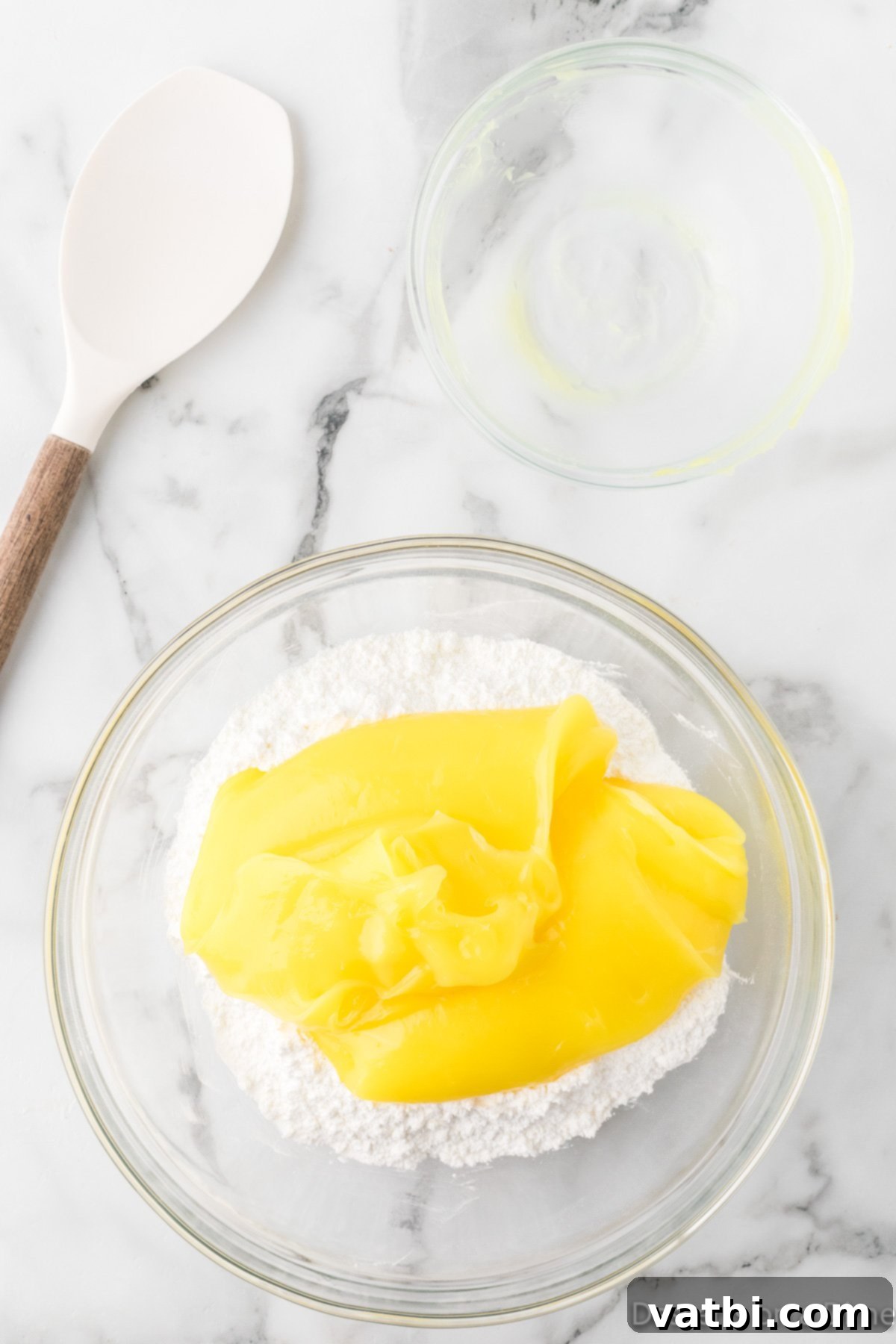 Mixing bowl with angel food cake mix and lemon pie filling being combined.