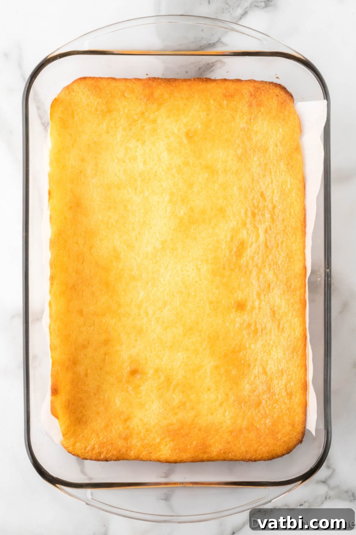 Baked lemon bars in a glass baking dish, fresh out of the oven.