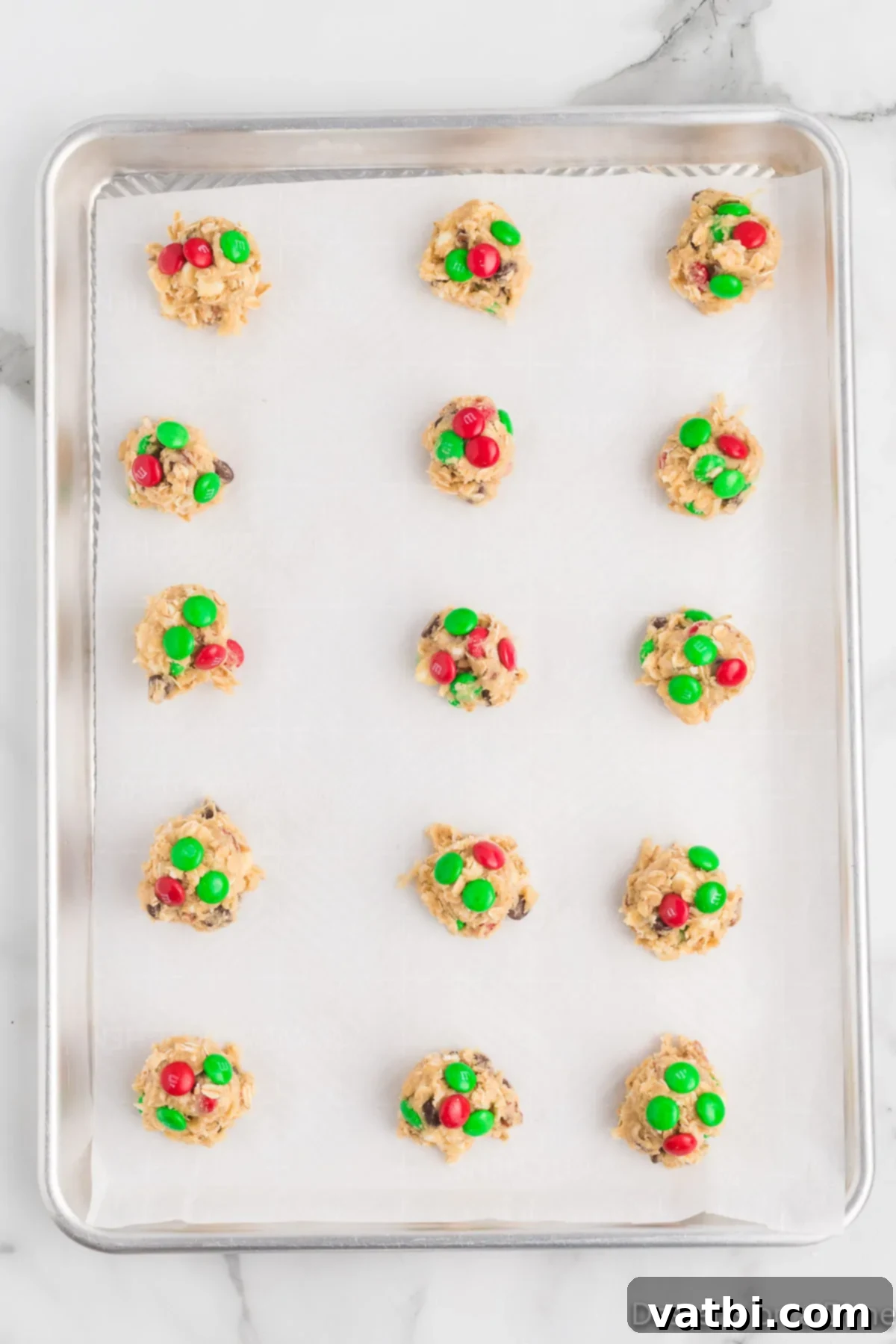 Festive Ranch Cookies 9 Carefully pressing the remaining red and green M&M's onto the tops of the scooped Christmas Cowboy Cookie dough balls on the parchment-lined baking sheet before baking.