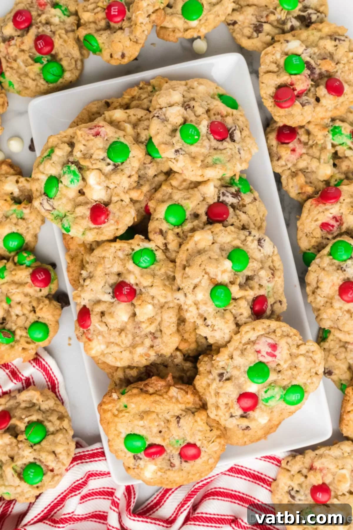 Festive Ranch Cookies 10 A beautiful, rustic platter filled with freshly baked Christmas Cowboy Cookies, showcasing the variety of delightful mix-ins like colorful M&M's, melted chocolate chips, and visible coconut flakes. Perfect for a holiday gathering.