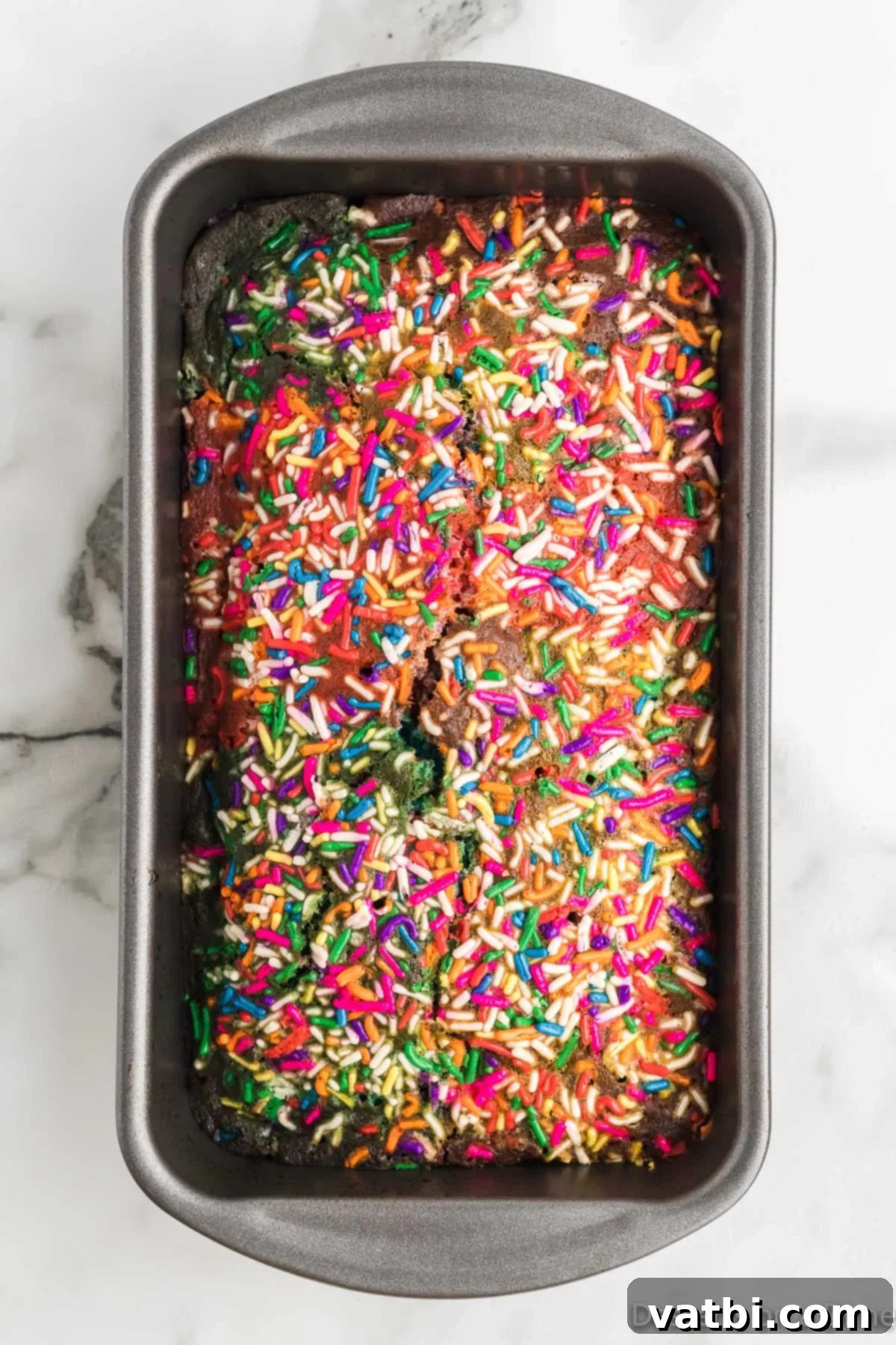 Rainbow Swirl Loaf 10 Baked Unicorn Bread cooling in the loaf pan.