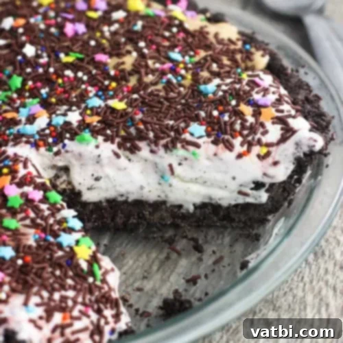Bake-Free Bliss: 69 Easy Pie Recipes 64 A slice of No Bake Ice Cream Pie with a cookie crust, topped with chocolate syrup.