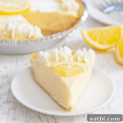 Bake-Free Bliss: 69 Easy Pie Recipes 5 A whole No Bake Lemon Pie on a white plate, garnished with lemon slices.