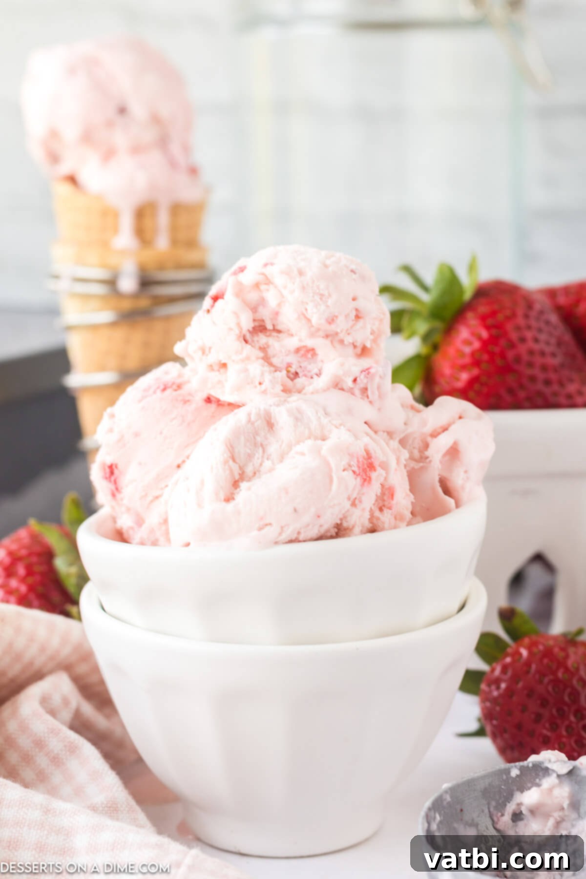 Easy No-Churn Strawberry Ice Cream 2 A bowl of creamy, pink no-churn strawberry ice cream, garnished with fresh strawberry slices, ready to be enjoyed.
