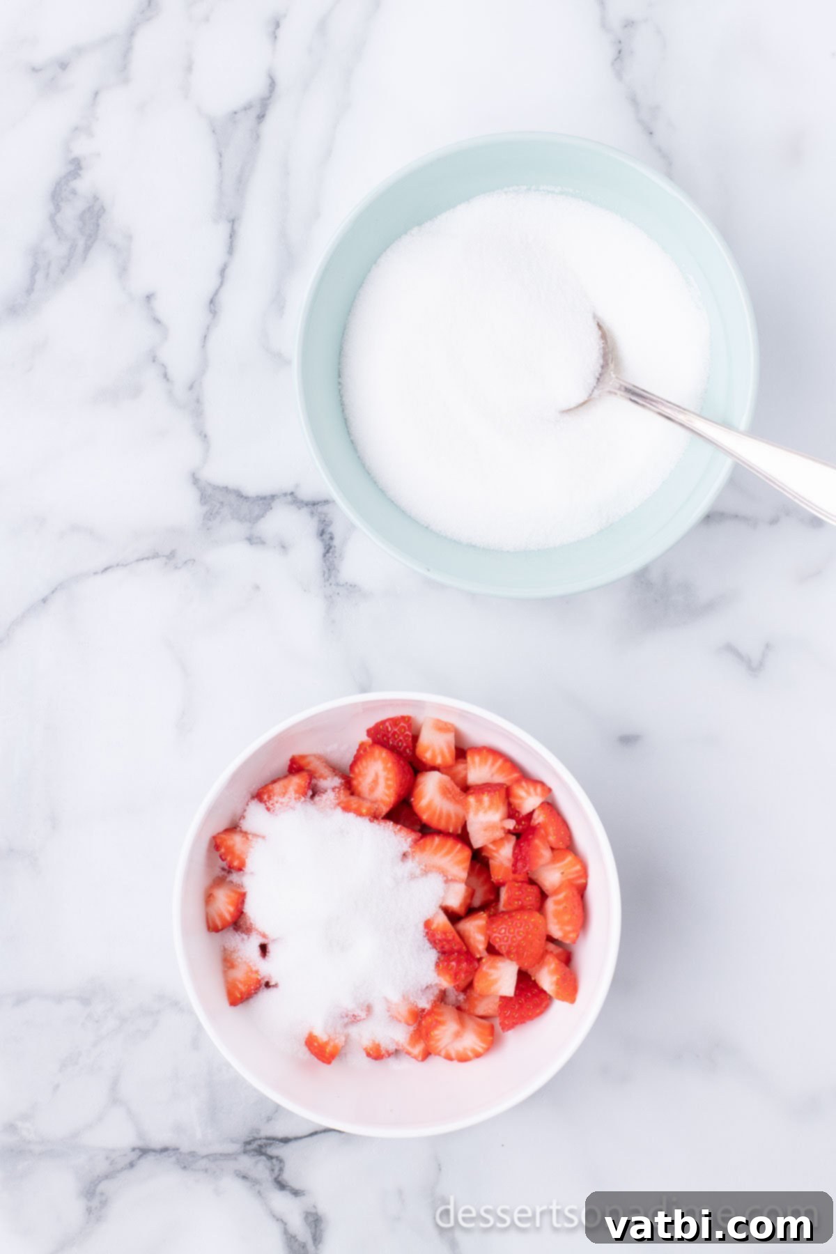 Easy No-Churn Strawberry Ice Cream 4 Diced strawberries are combined with white granulated sugar in a small bowl, beginning the maceration process.