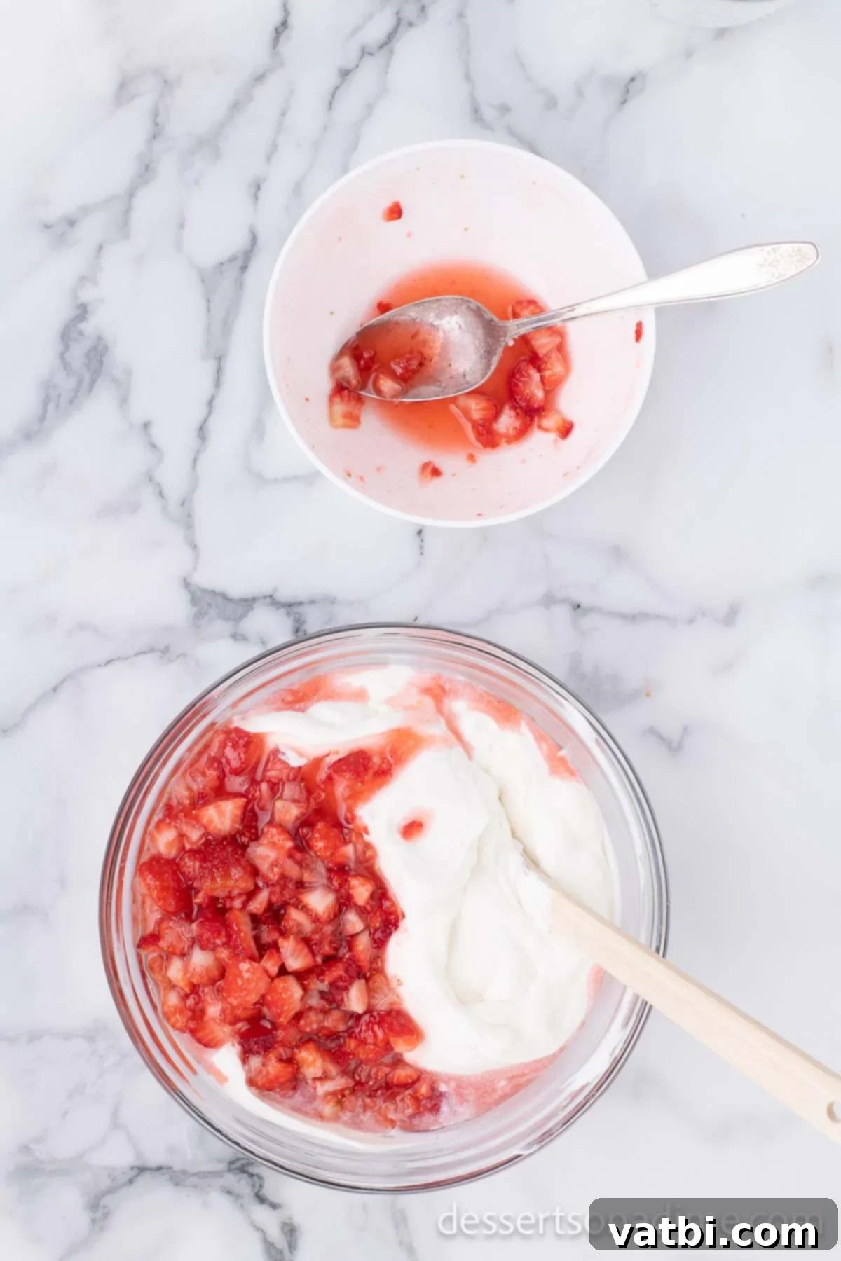 Easy No-Churn Strawberry Ice Cream 7 The macerated strawberry mixture, including its flavorful juices, is added to the creamy base in the mixing bowl.