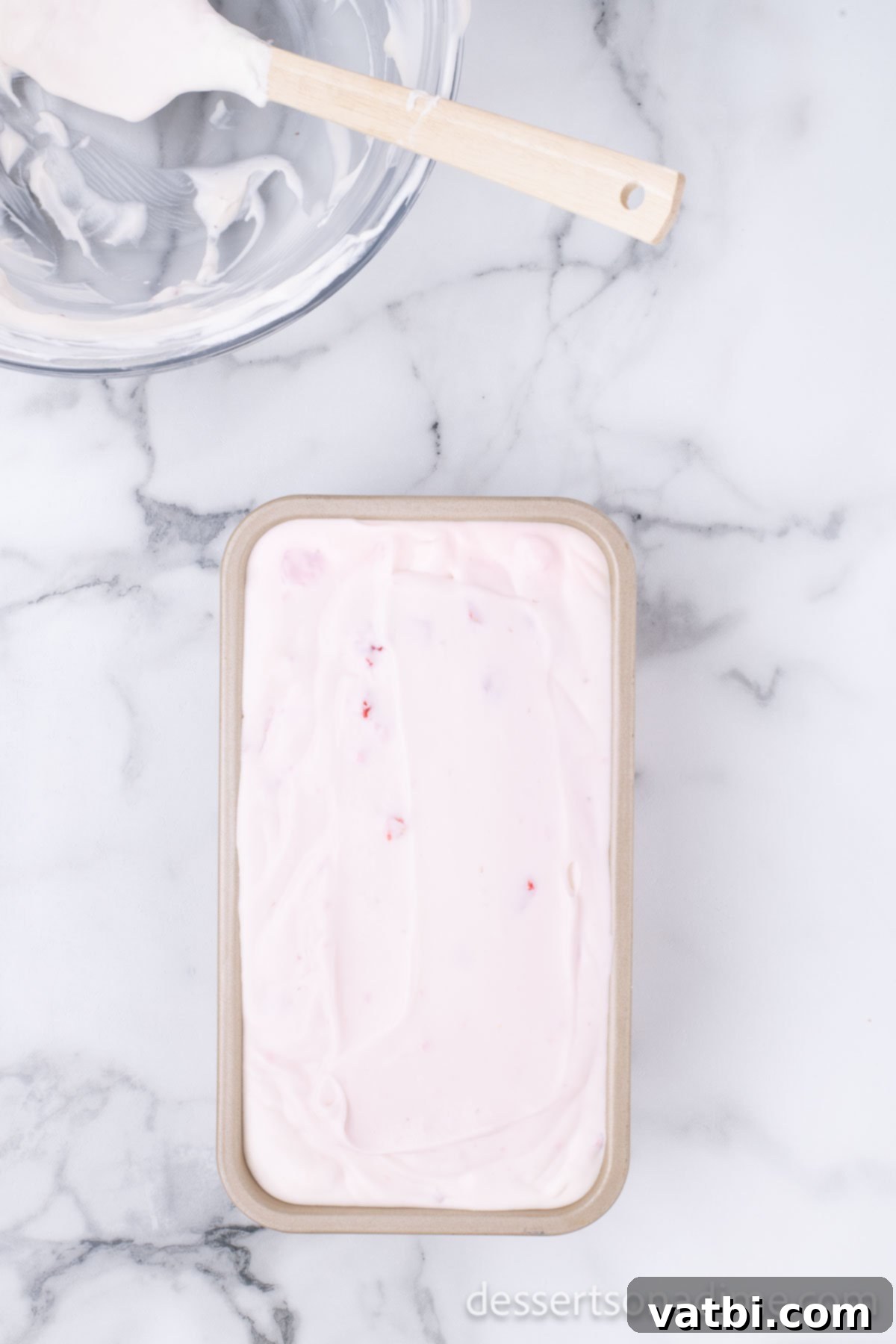 Easy No-Churn Strawberry Ice Cream 9 The mixed strawberry ice cream batter is spread evenly into a standard loaf pan, ready for freezing.