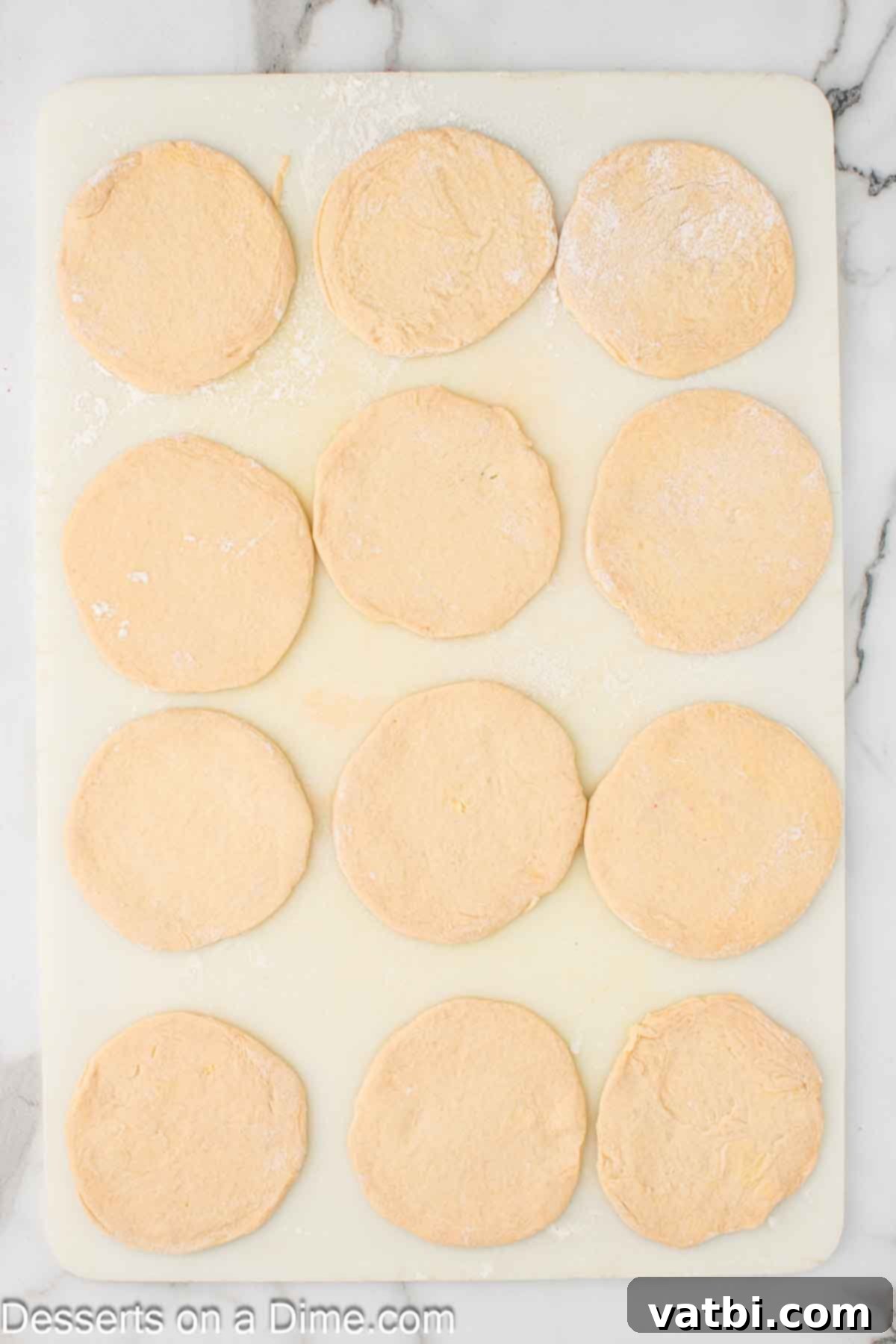 Air-Fried Apple Pie Puffs 5 Biscuit layers rolled into approximately 4-inch circles on a cutting board.
