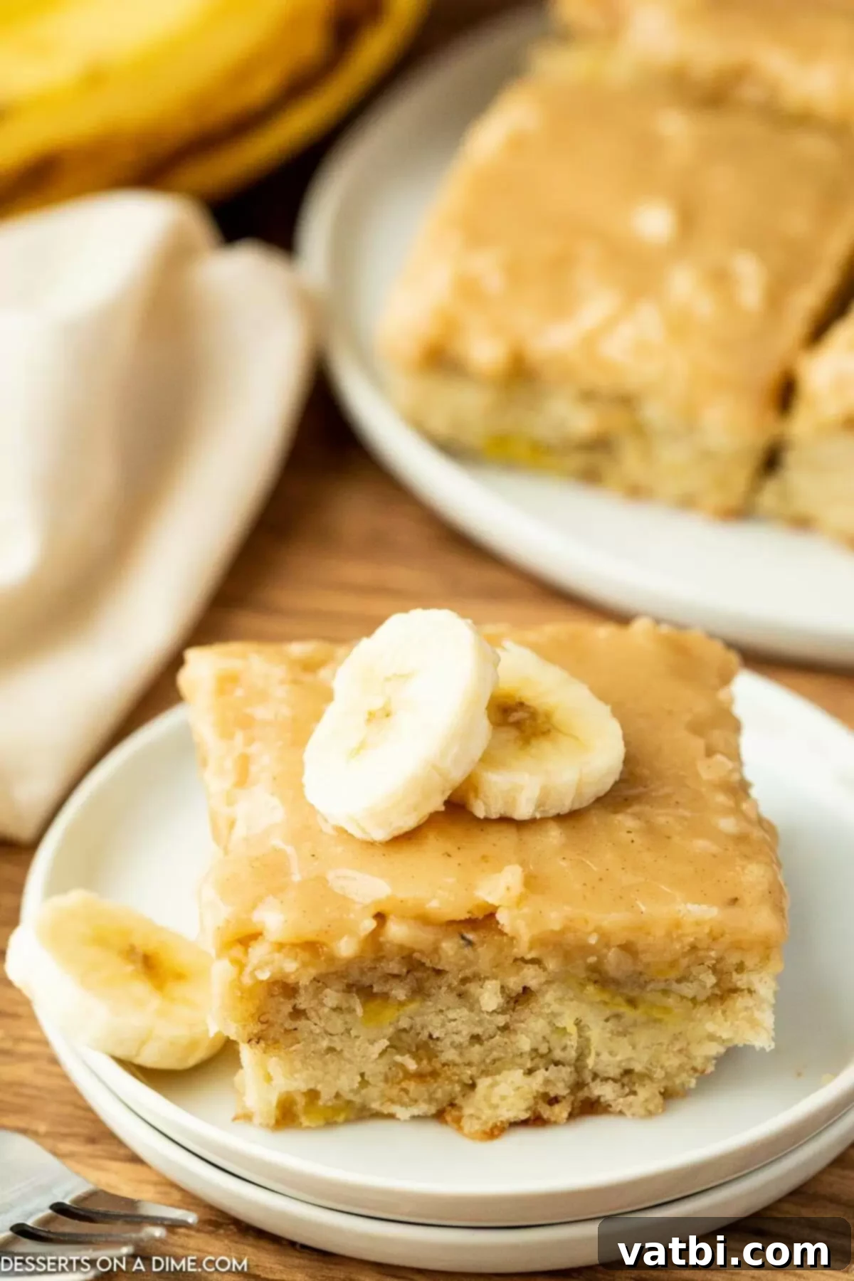 Fudgy Banana Bread Brownies 12 Close-up of a square of banana bread brownie with creamy brown butter frosting, ready to be enjoyed.