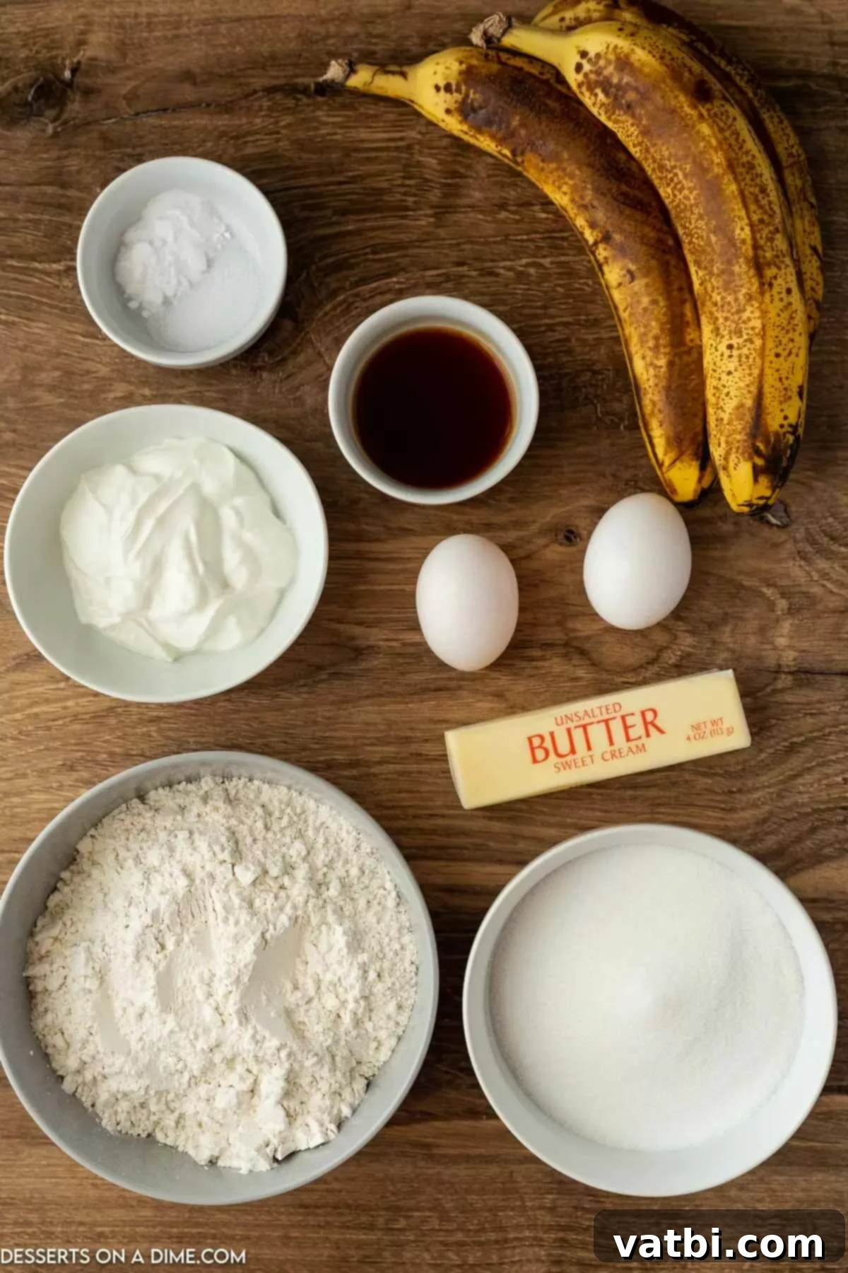 Fudgy Banana Bread Brownies 3 A collection of ingredients for making banana bread brownies including sugar, sour cream, butter, eggs, ripe bananas, vanilla, brown sugar, and powdered sugar, all neatly arranged for baking.