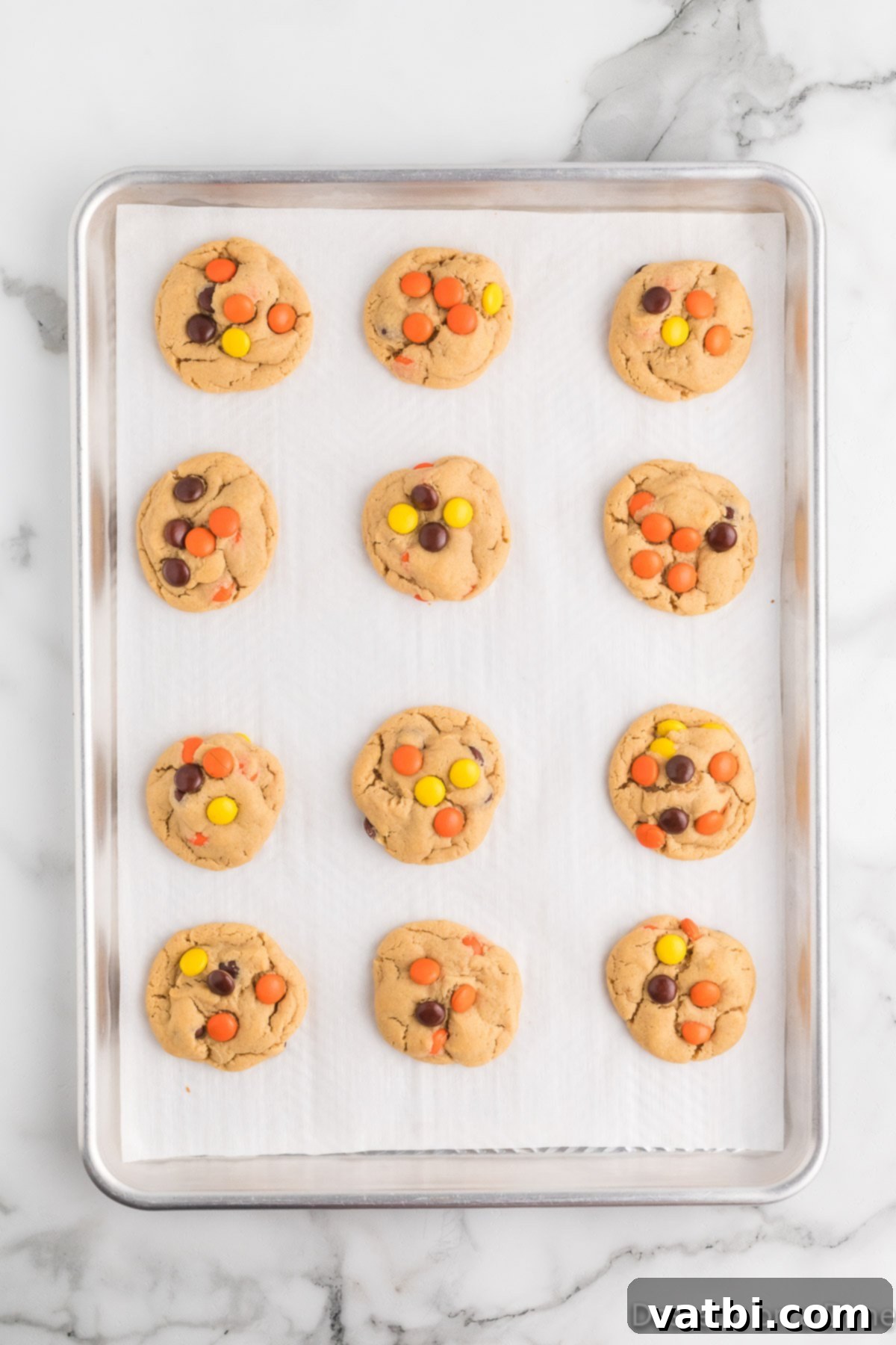 Reese's Pieces Peanut Butter Perfection 11 Freshly baked Reese's Pieces Cookies cooling on a baking sheet.