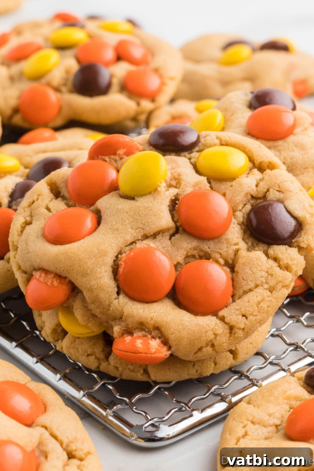 Reese's Pieces Peanut Butter Perfection 12 Freshly baked Reese's Pieces Cookies cooling on a wire rack after being removed from the baking sheet.