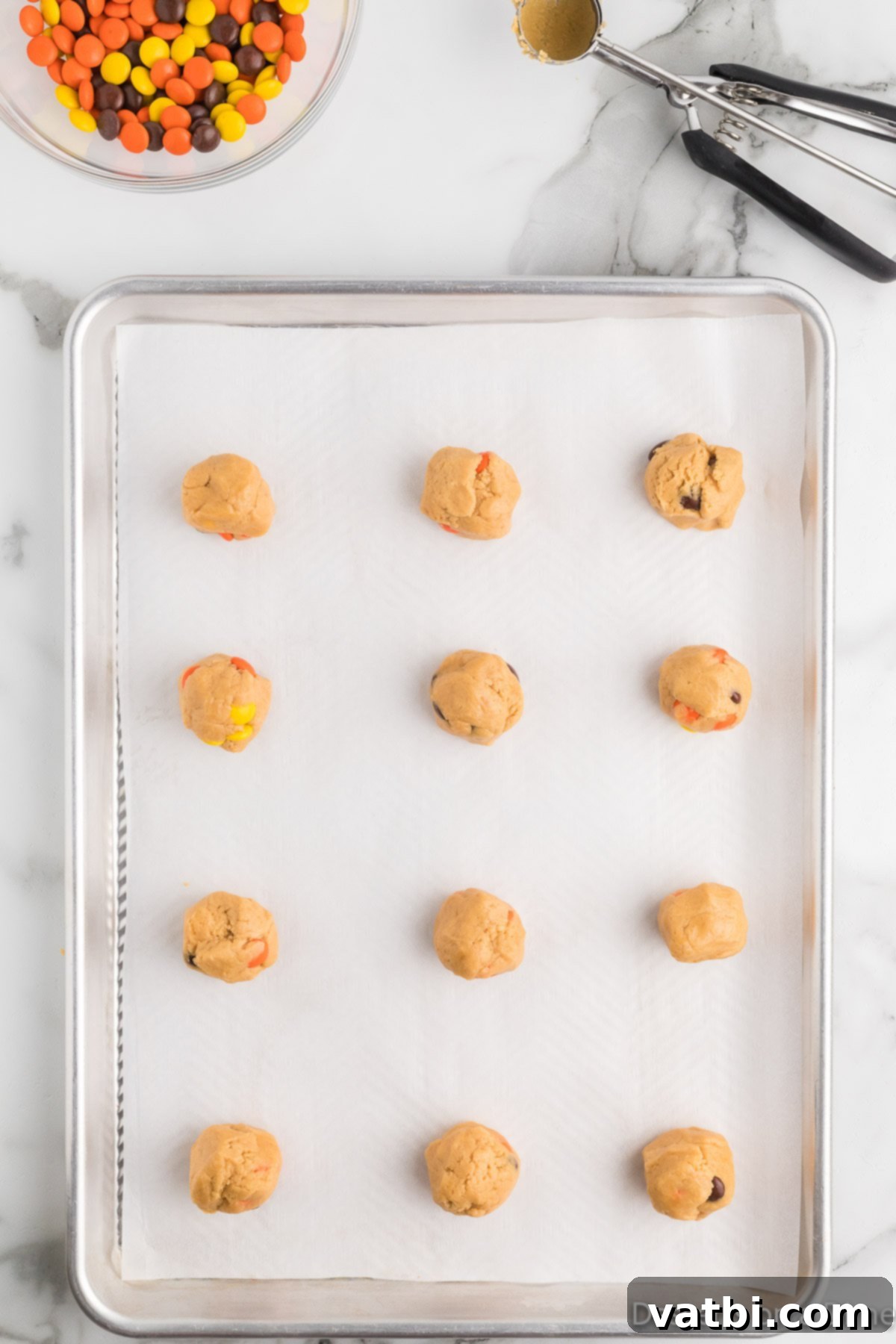 Reese's Pieces Peanut Butter Perfection 9 Cookie dough scooped into balls and placed on a parchment-lined baking sheet.