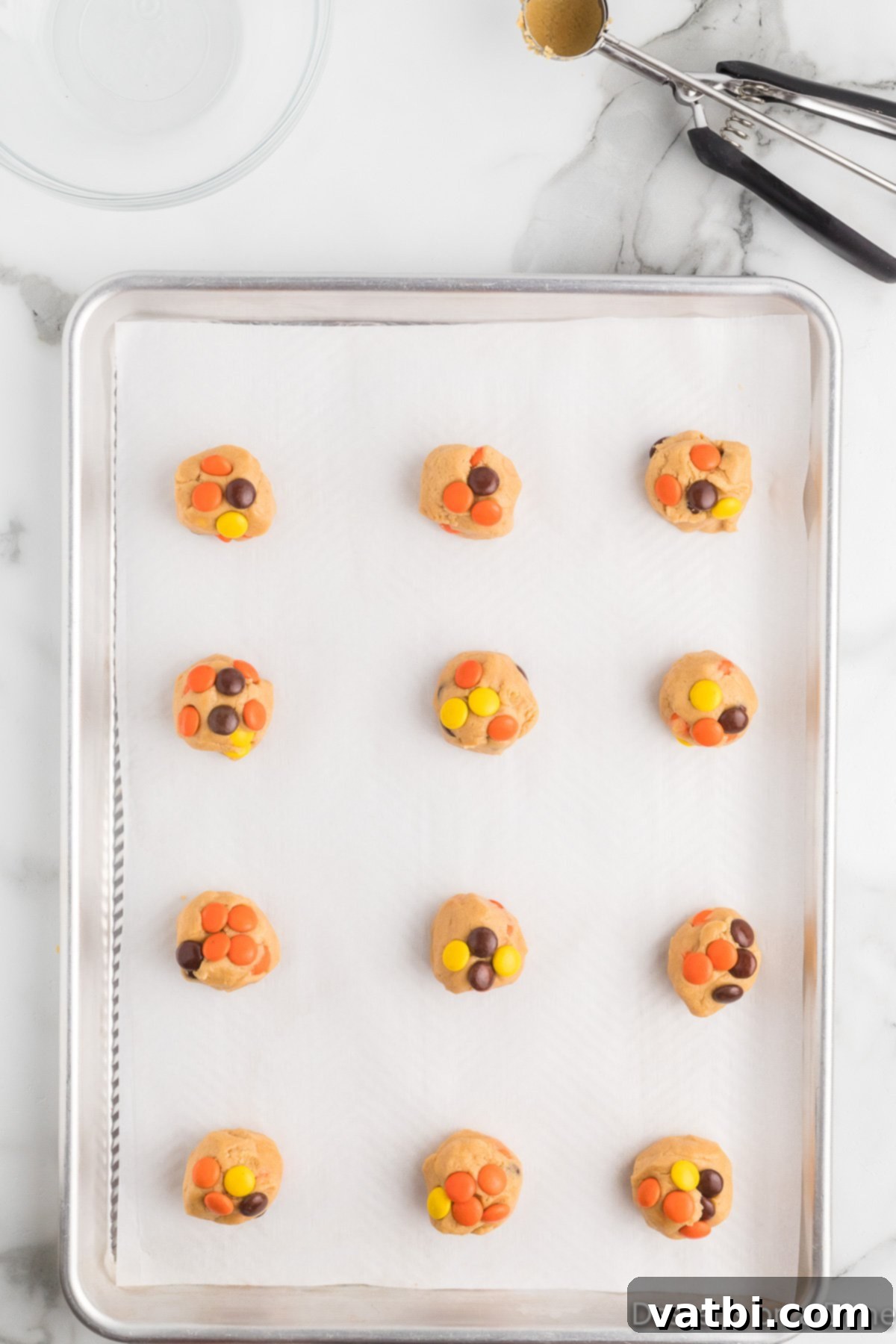 Reese's Pieces Peanut Butter Perfection 10 Cookie dough balls topped with additional Reese's Pieces candies before baking.