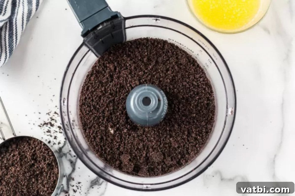 Decadent No-Bake Oreo Lasagna 2 Oreo cookies being crushed in a food processor
