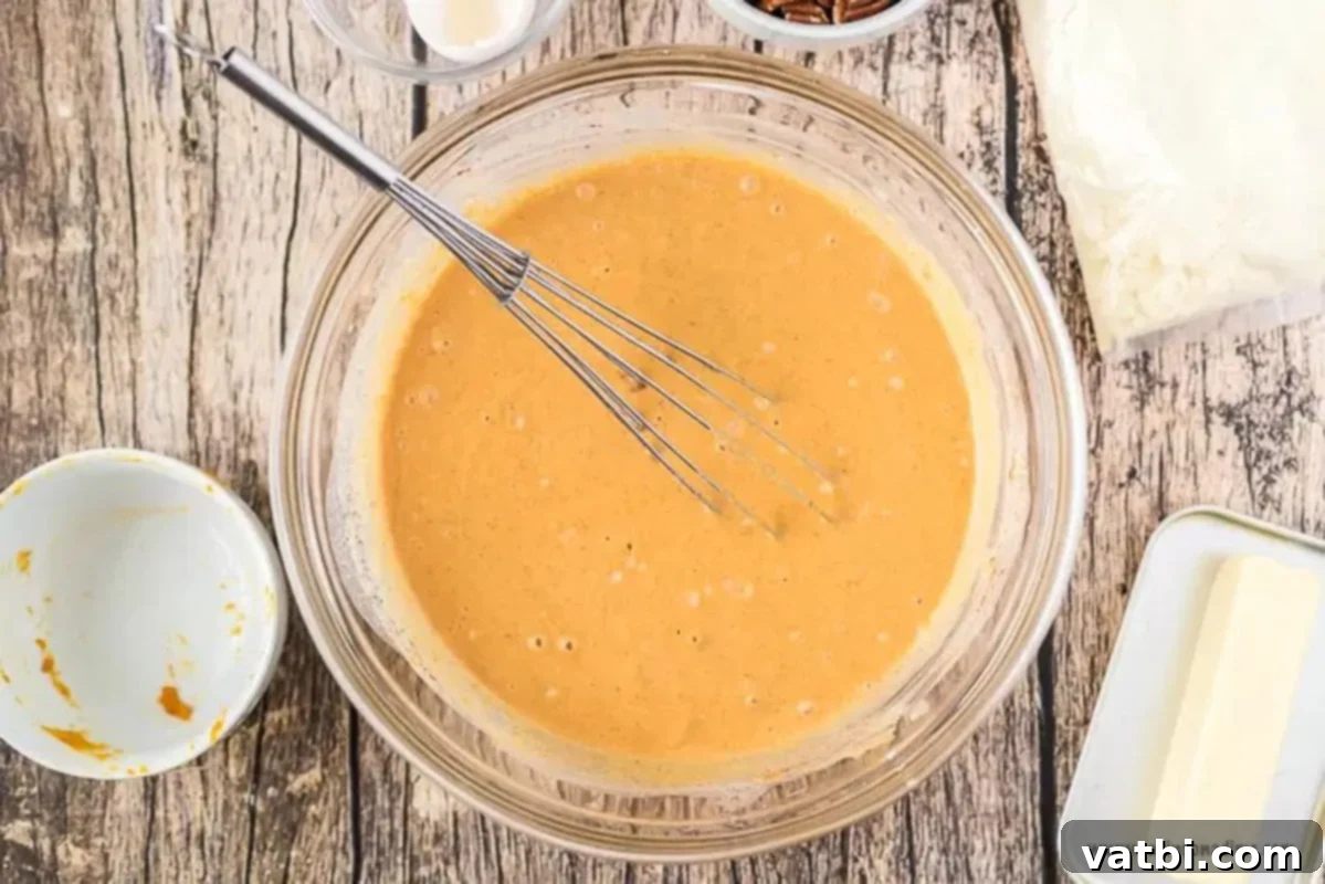 Ultimate Pumpkin Pie Cake 2 Mixing bowl with pumpkin mixture for pumpkin pie cake.