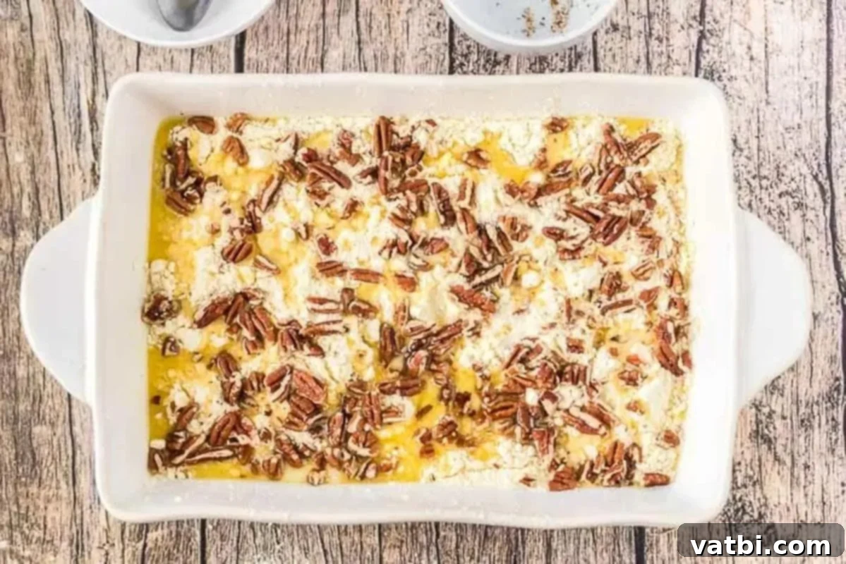 Ultimate Pumpkin Pie Cake 4 Dry cake mix spread over pumpkin mixture, then topped with melted butter and chopped nuts.