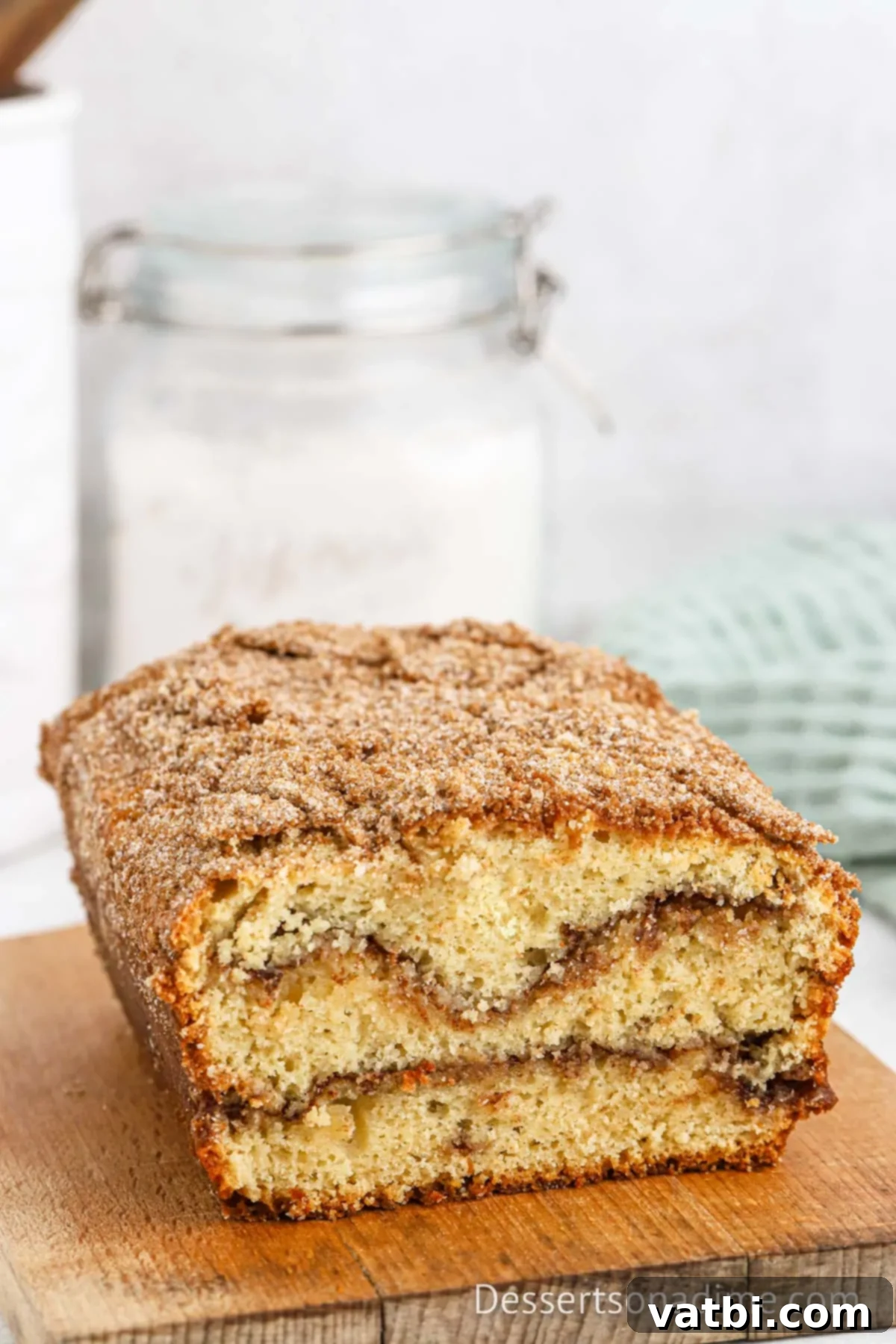 Cinnamon Sugar Snickerdoodle Bread 12 A perfectly baked loaf of Snickerdoodle Bread on a cutting board, ready to be sliced.