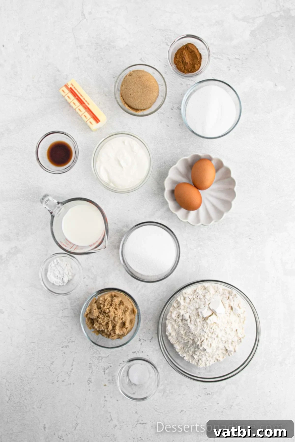Cinnamon Sugar Snickerdoodle Bread 3 Various ingredients laid out for cinnamon swirl bread: flour, cinnamon, sugar, butter, vanilla extract, and eggs.