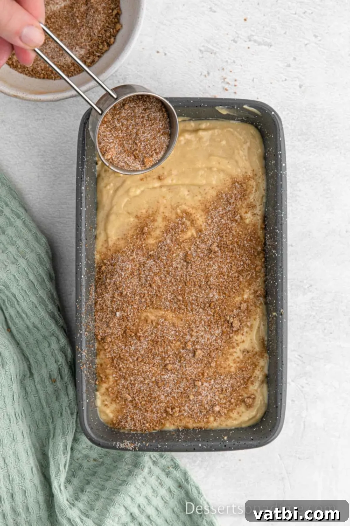 Cinnamon Sugar Snickerdoodle Bread 9 Cinnamon swirl mixture sprinkled on top of the first layer of bread batter in the loaf pan.