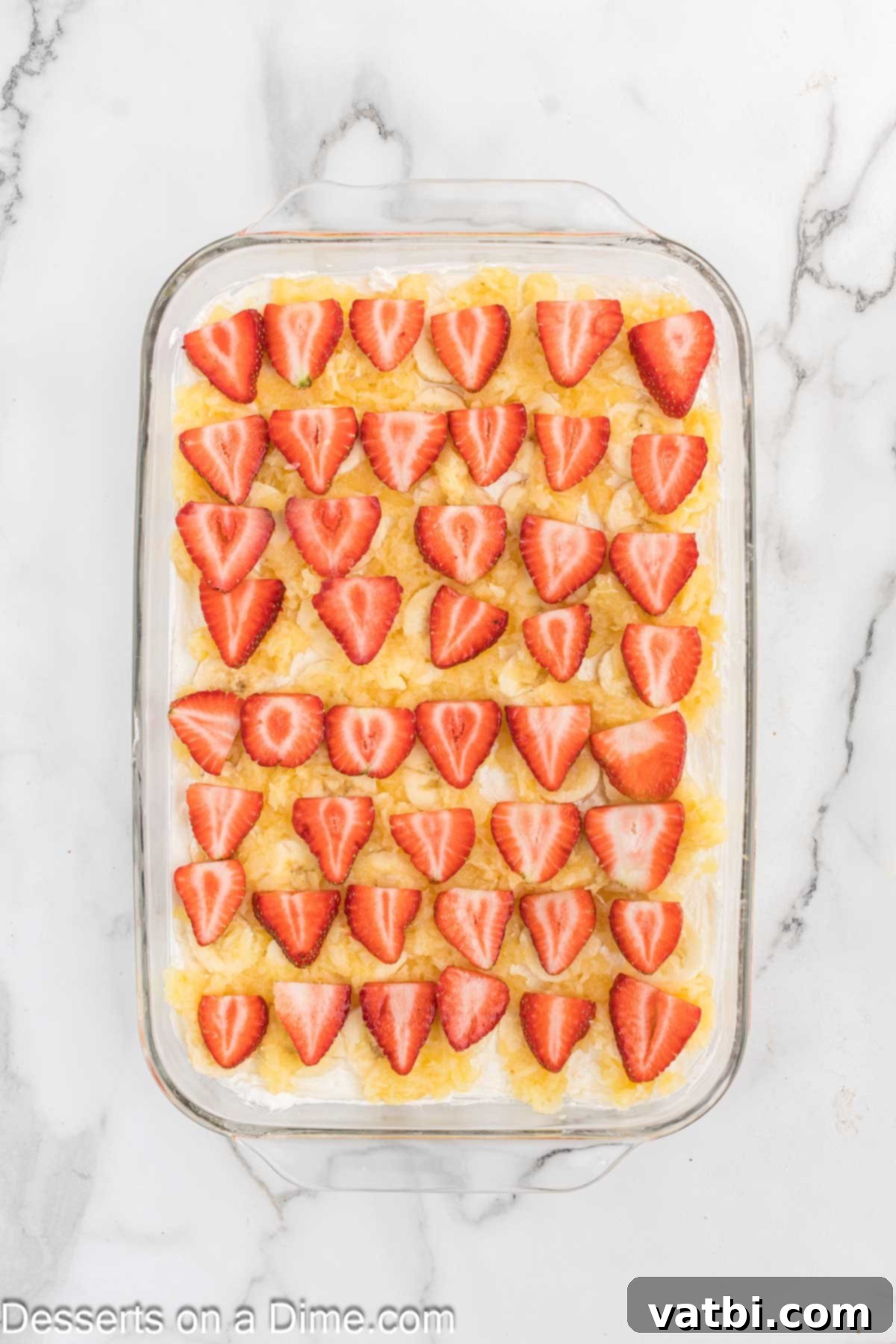 Strawberry slices on top of pineapple. 