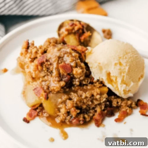 Bacon Caramel Apple Crisp in a baking dish, served with ice cream.