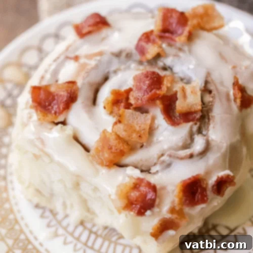 Warm Maple Bacon Cinnamon Rolls drizzled with maple glaze.
