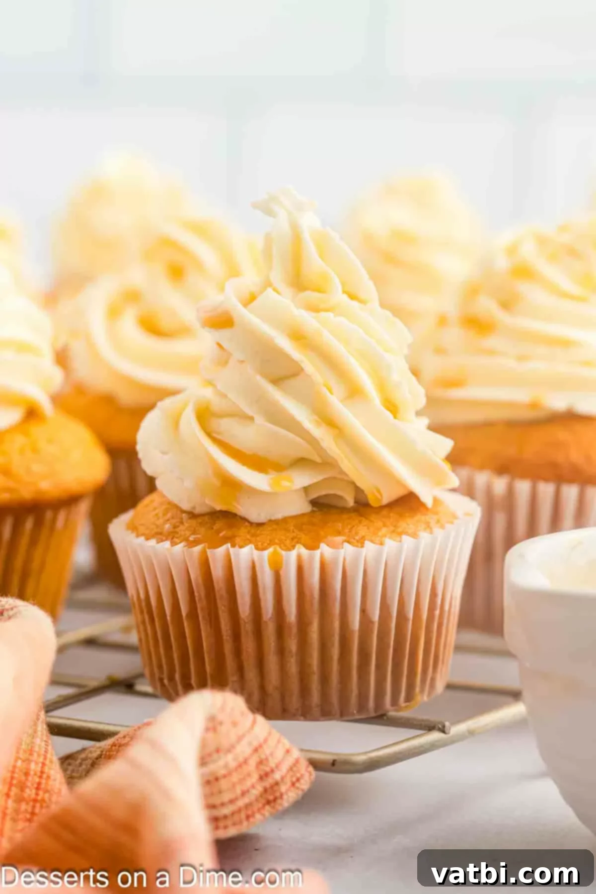 Close-up of fluffy Butterscotch Cupcakes ready to enjoy, with a swirl of frosting and a golden drizzle.