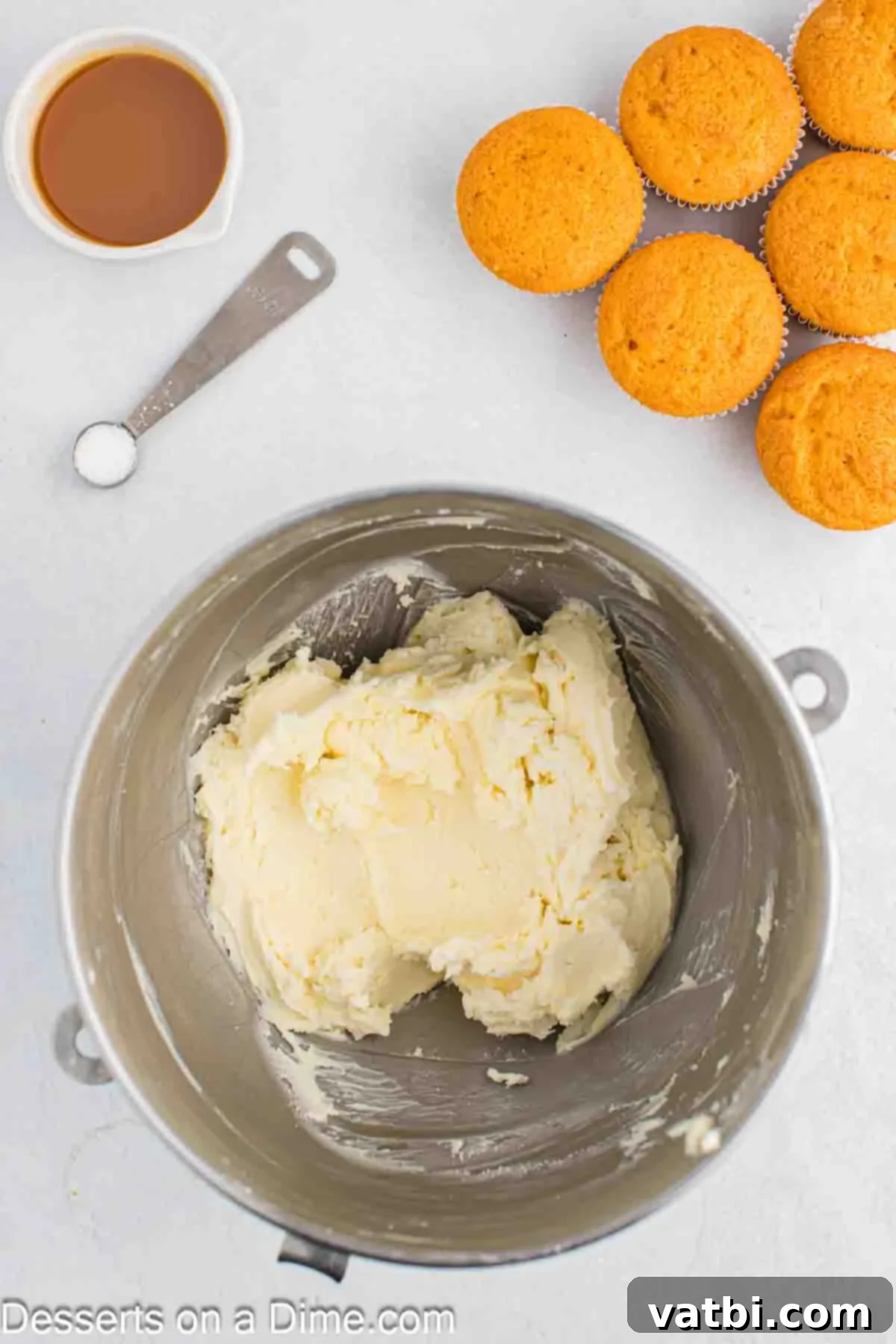 Powdered sugar being gradually added to the fluffy butter mixture in a bowl.