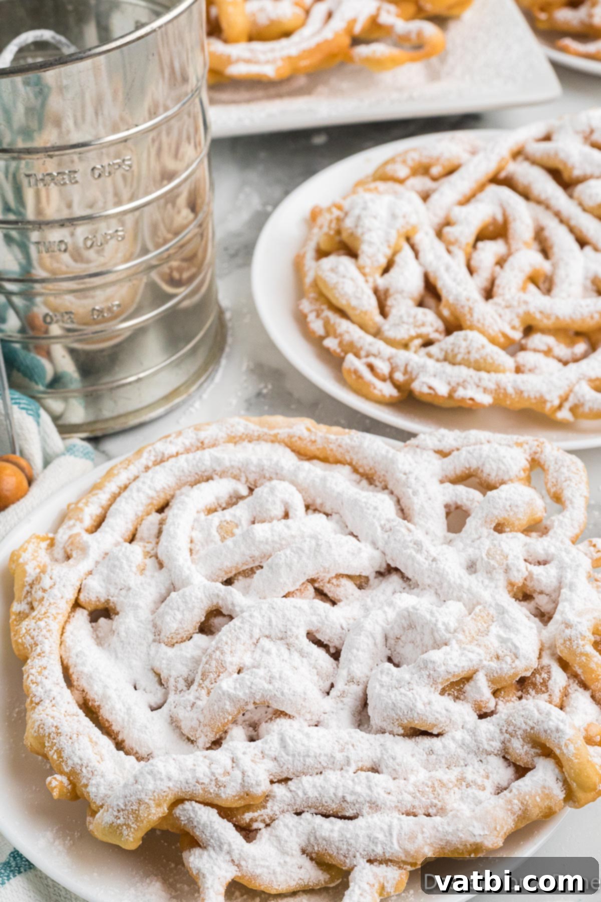 Sweet Funnel Cake Perfection 12 A beautifully fried funnel cake, generously dusted with powdered sugar, ready for serving.