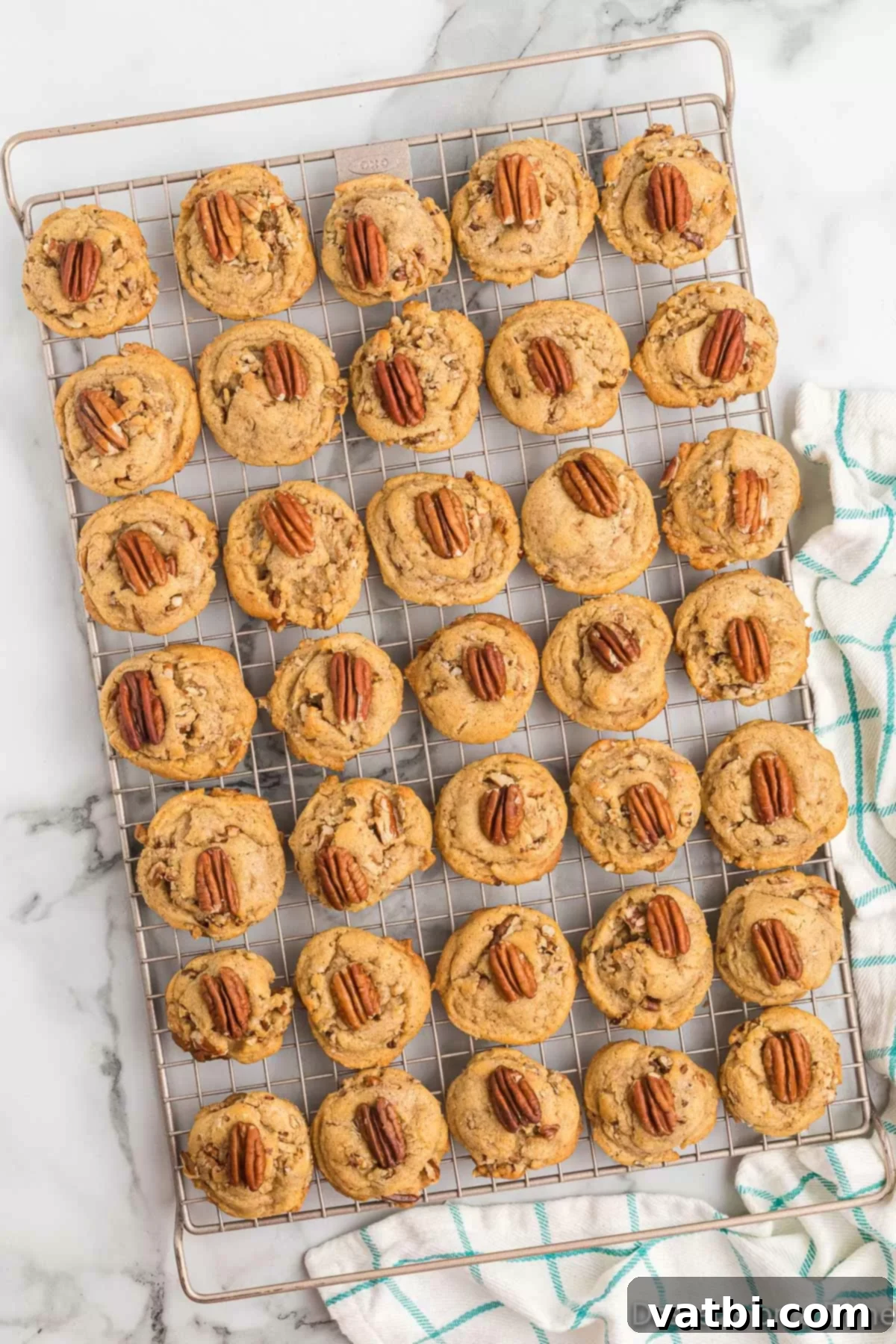 Classic Butter Pecan Cookies 14 Freshly baked butter pecan cookies cooling on a wire rack after being removed from the oven, showing their golden edges.