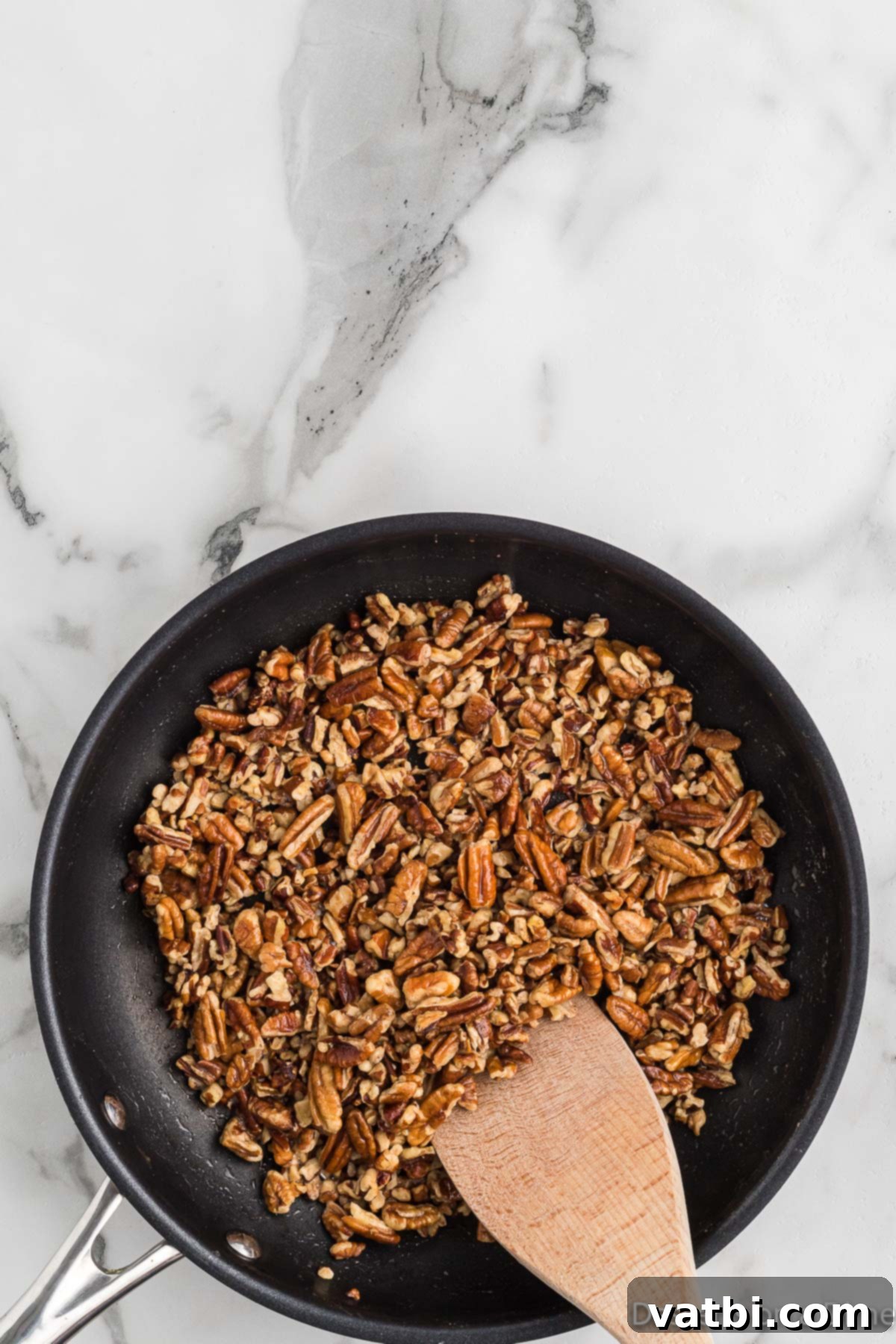 Classic Butter Pecan Cookies 5 Toasted pecans mixed with browned butter, showing a golden-brown hue after being cooked in a skillet.