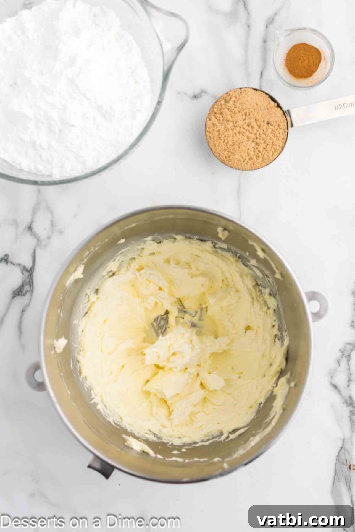 Apple Crumble Cupcakes 7 Smooth, creamy buttercream frosting being mixed in a large bowl with an electric mixer.