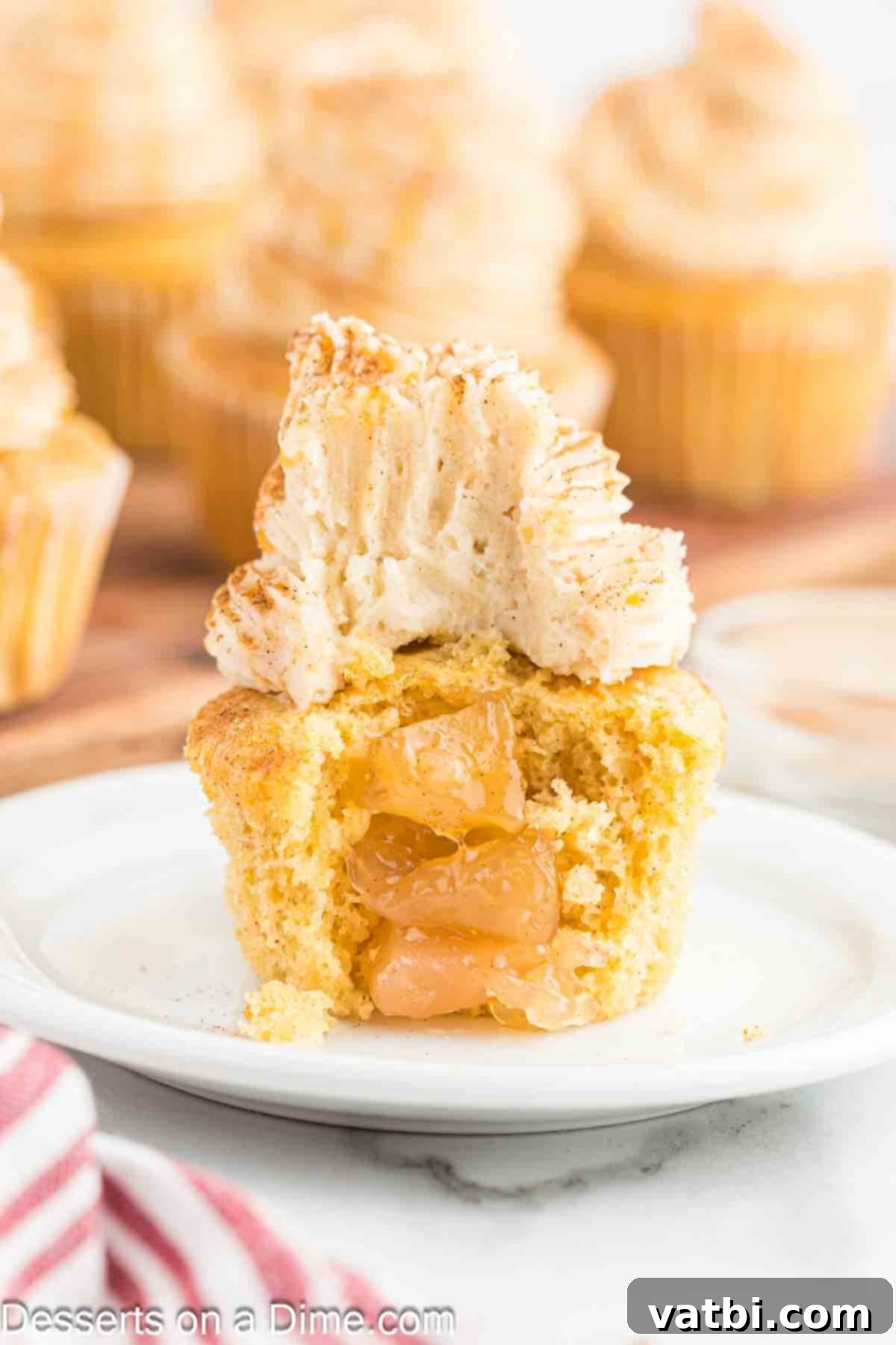 Apple Crumble Cupcakes 10 Close-up of a frosted apple pie cupcake with caramel drizzle, ready for a delicious bite.