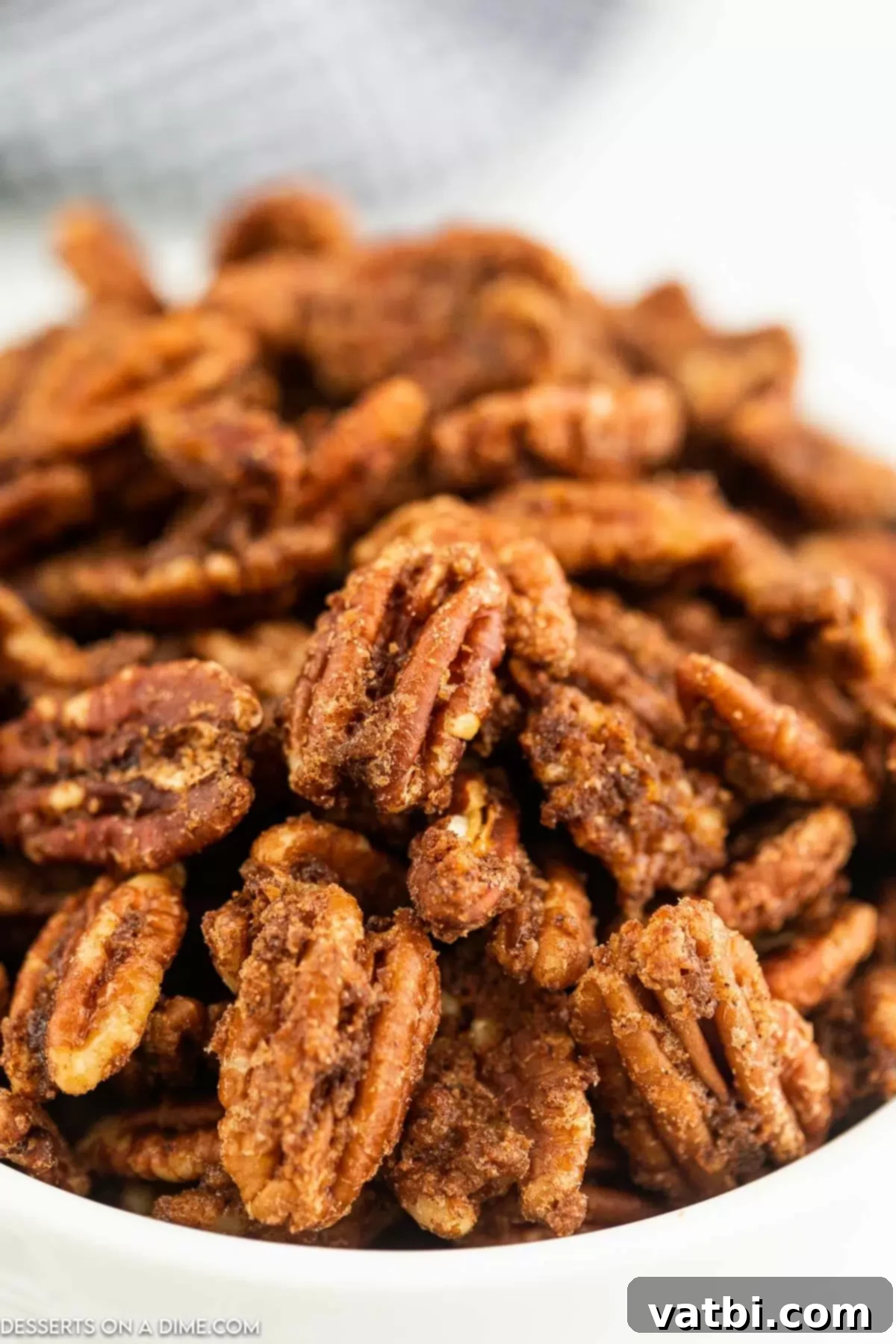 A bowl filled with golden-brown, glistening Air fryer candied pecans.