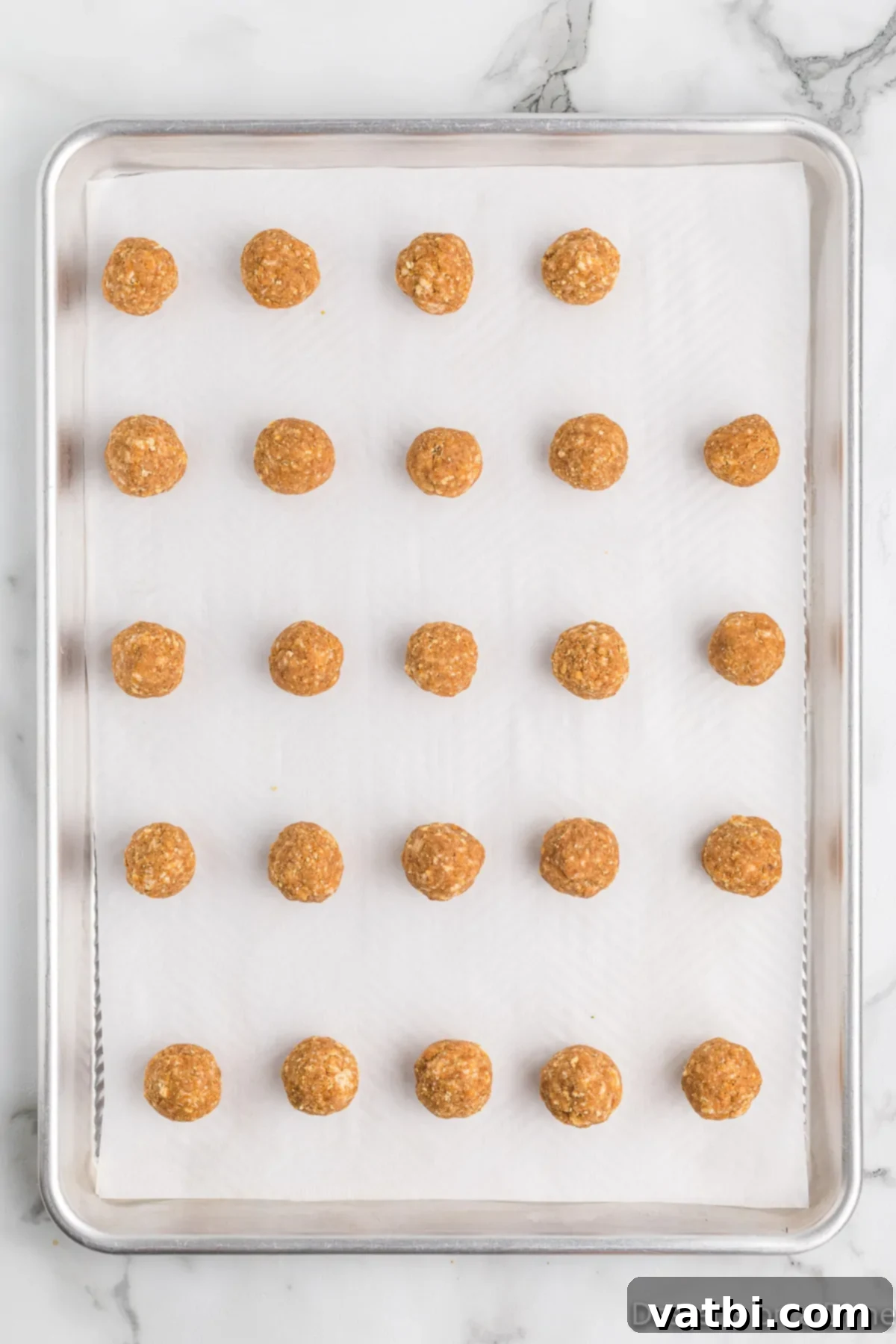 Pumpkin Spice Truffles 8 Small, un-coated pumpkin truffle balls neatly arranged on a baking sheet.