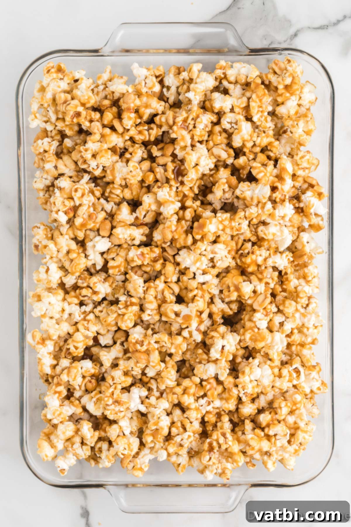 Buttery Toffee Bliss Popcorn 10 Toffee-coated popcorn spread evenly on a baking sheet lined with parchment paper.