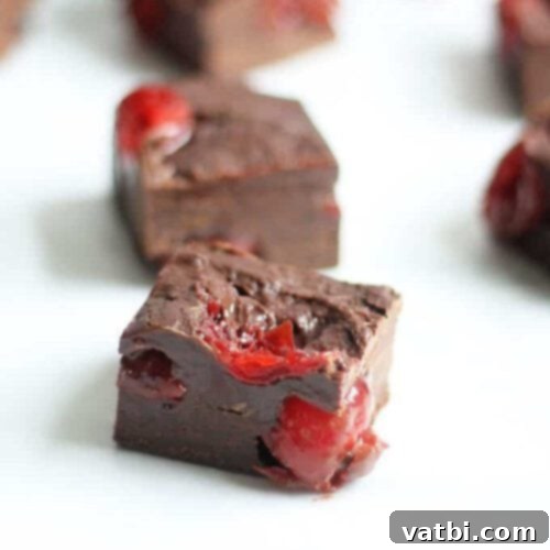 55 Festive & Easy Christmas Fudge Ideas 8 Dark Chocolate and Cherry Fudge squares, rich in color.