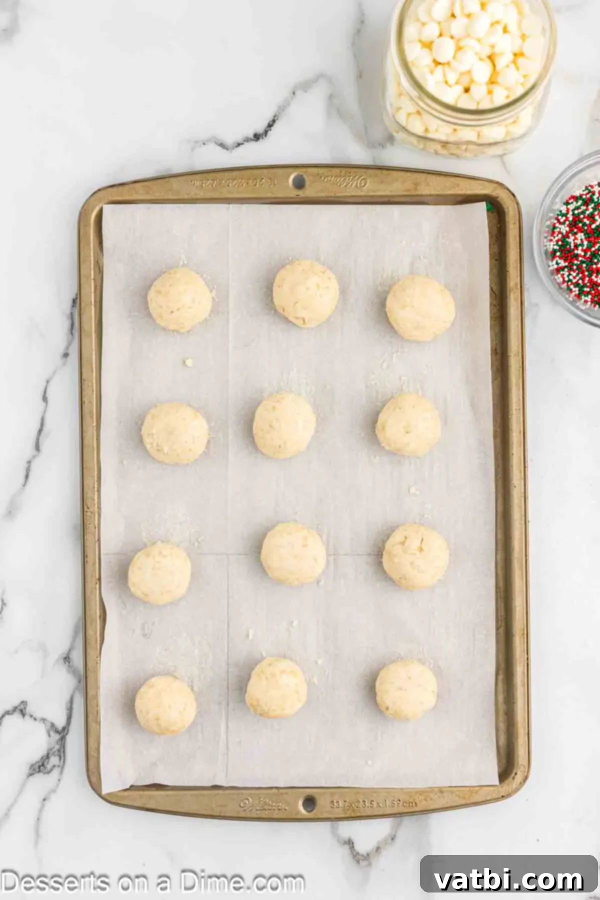 Placing the formed sugar cookie balls on the baking sheet