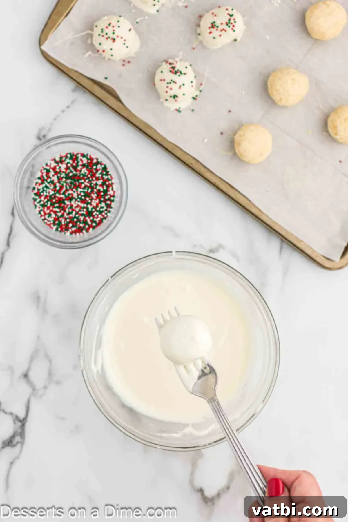 Dipping the sugar cookie balls into the melted chocolate